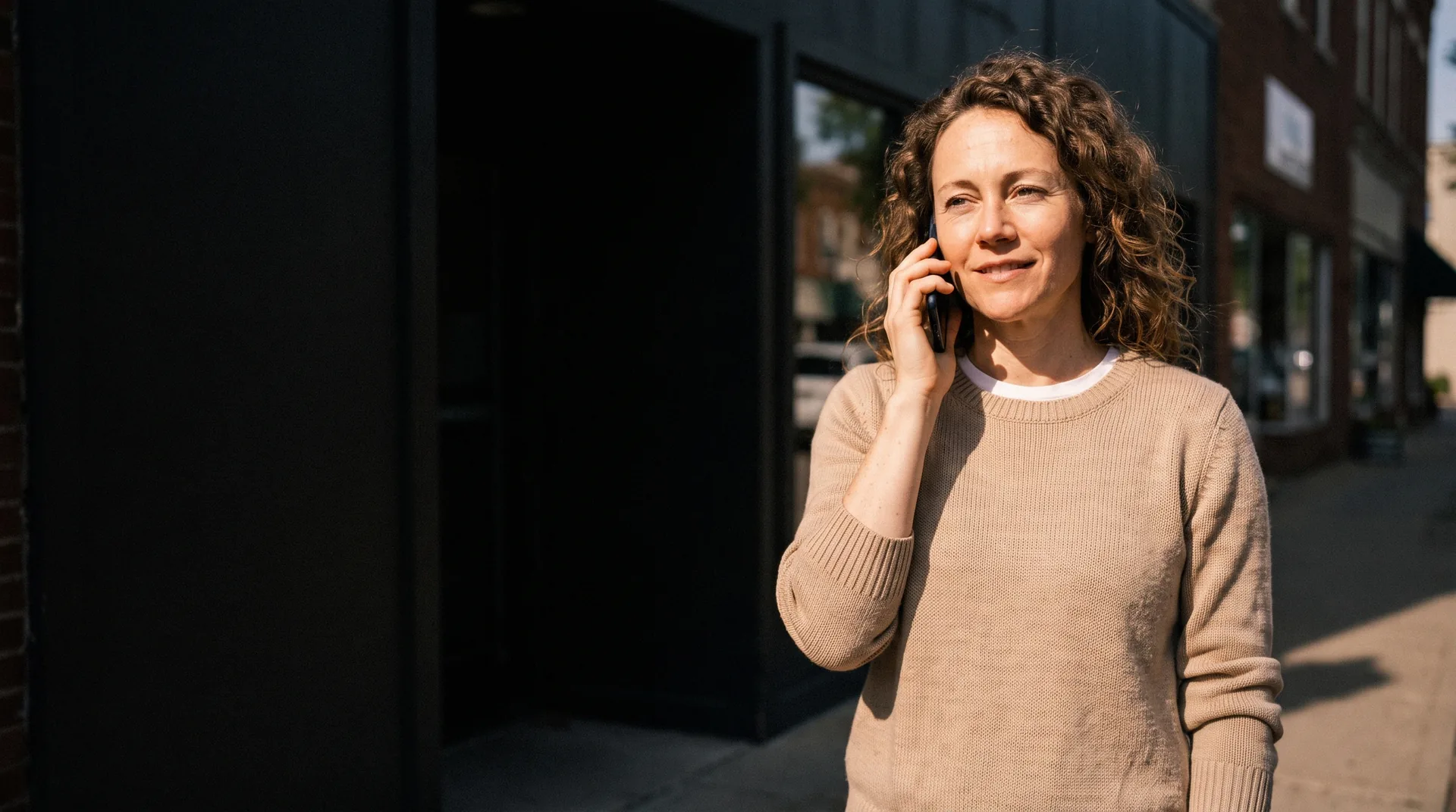 A business owner taking a call outside their premises